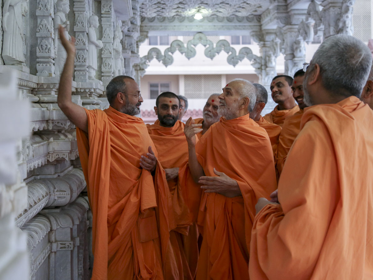 Swamishri observes a carving in mandir pradakshina