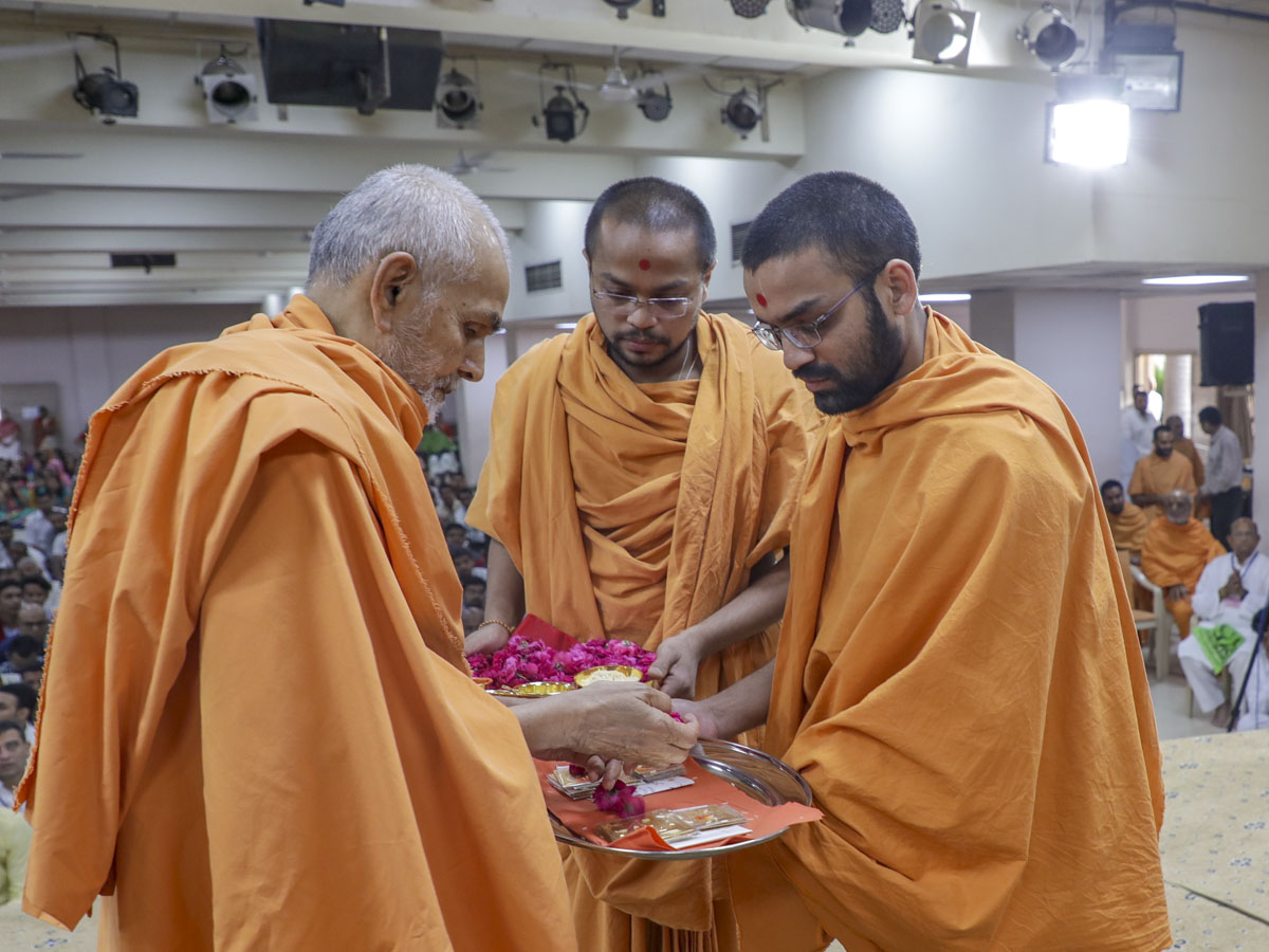 Swamishri sanctifies yantras to be placed beneath the murtis