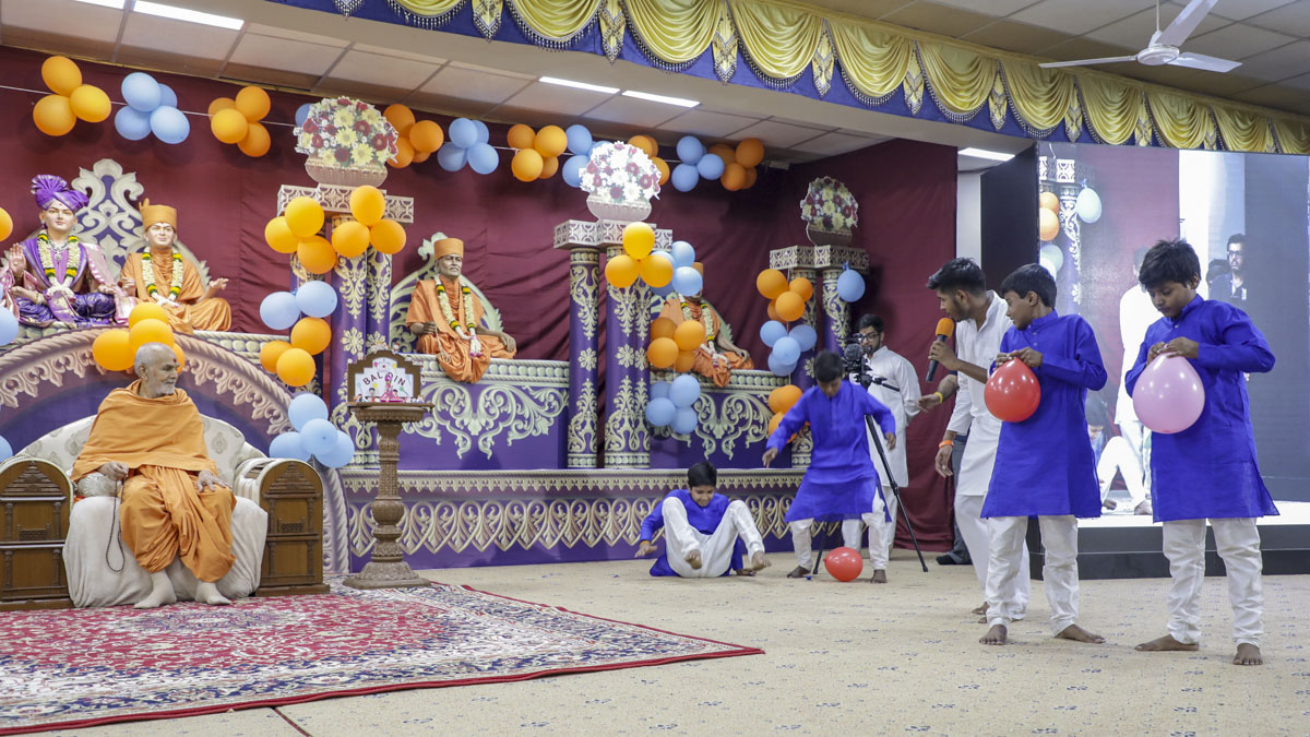 Children perform an activity before Swamishri