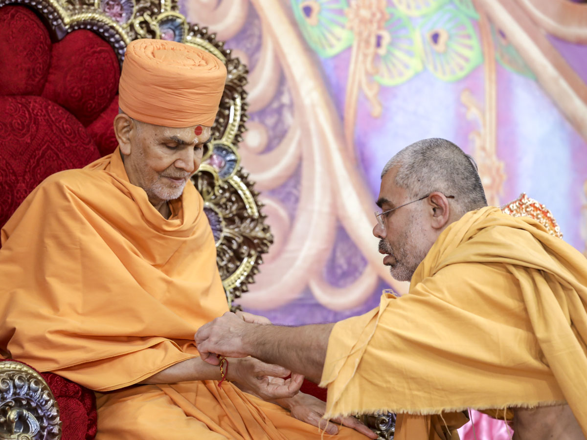 Bhaktivedanta Swami ties a nadachhadi to Swamishri