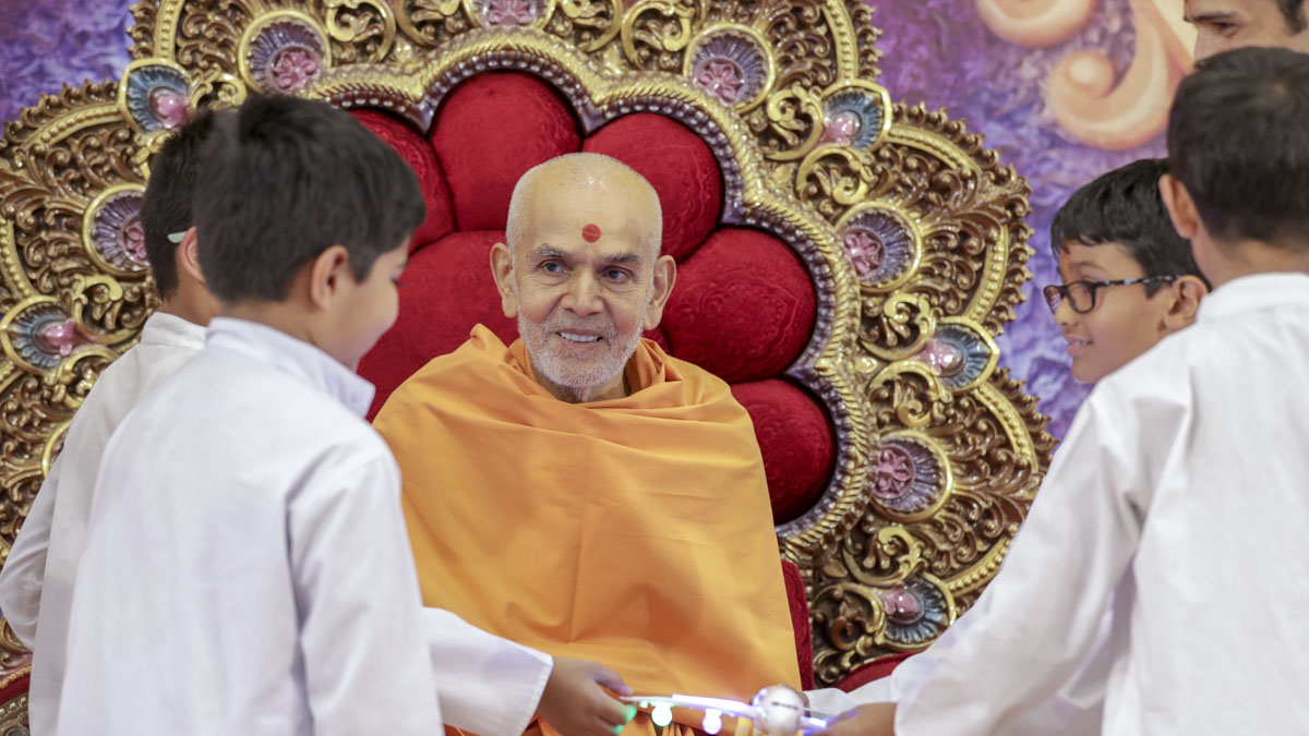 Swamishri participates in an activity with the children