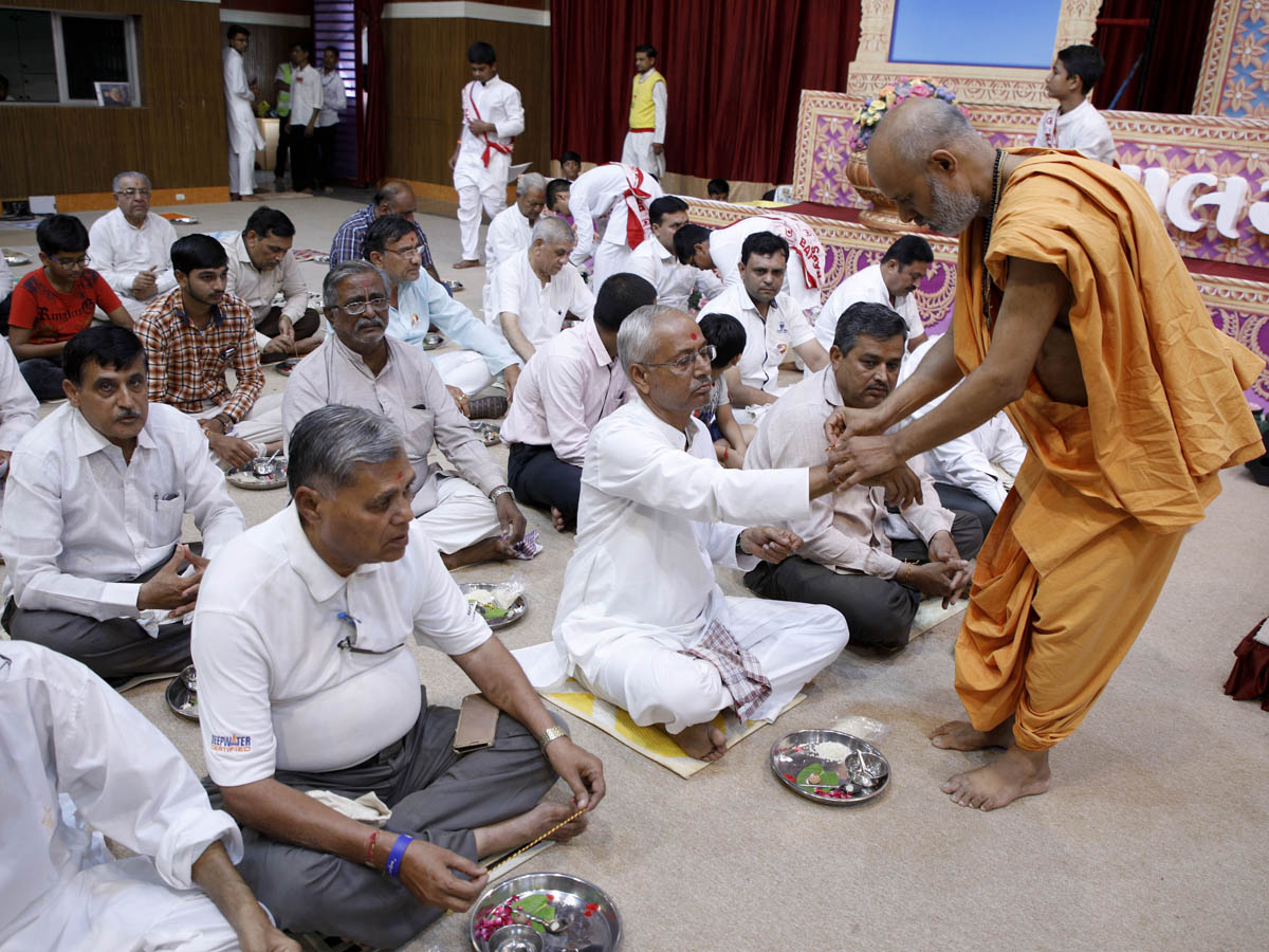 Devotees participate in the evening parayan pujan rituals