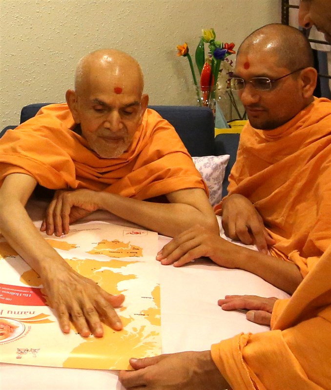 Mahant Swami Maharaj observes the map for the events - Singapore, 6 April 2018