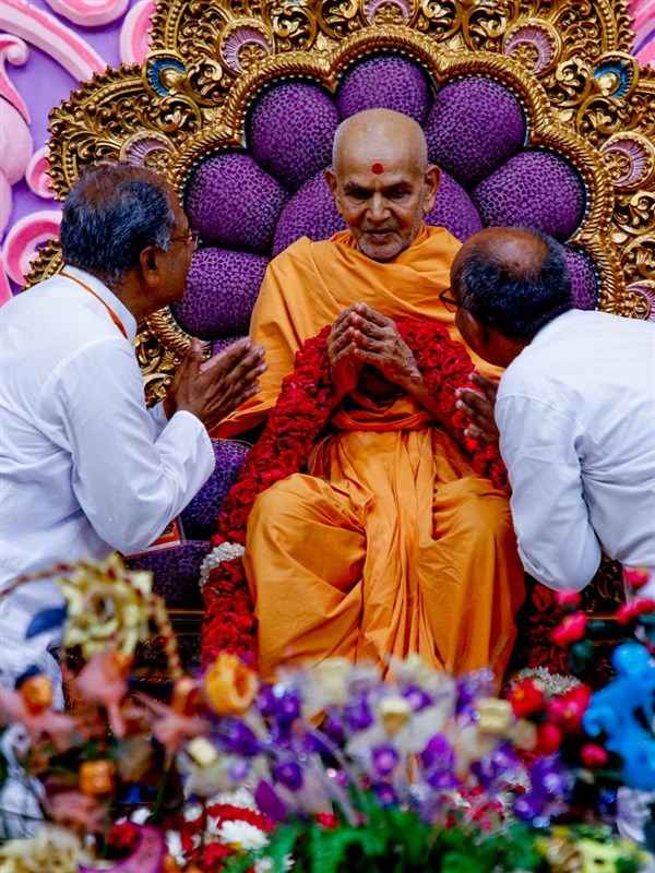 Senior volunteers honor Swamishri with a garland
