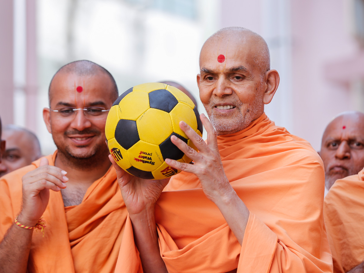 Swamishri sanctifies a football