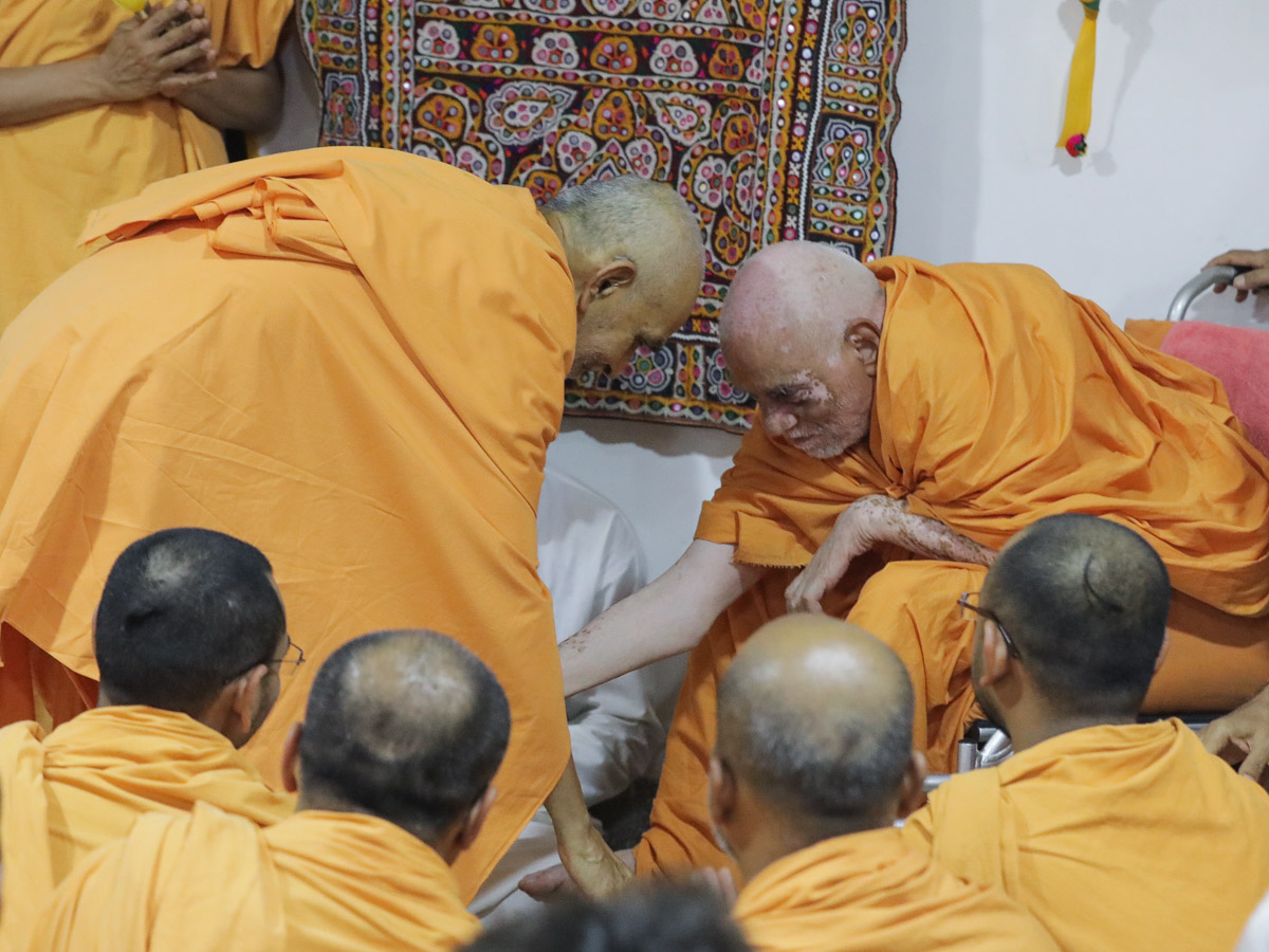 Swamishri reverently greets Devcharan Swami with 'Jai Swaminarayan'