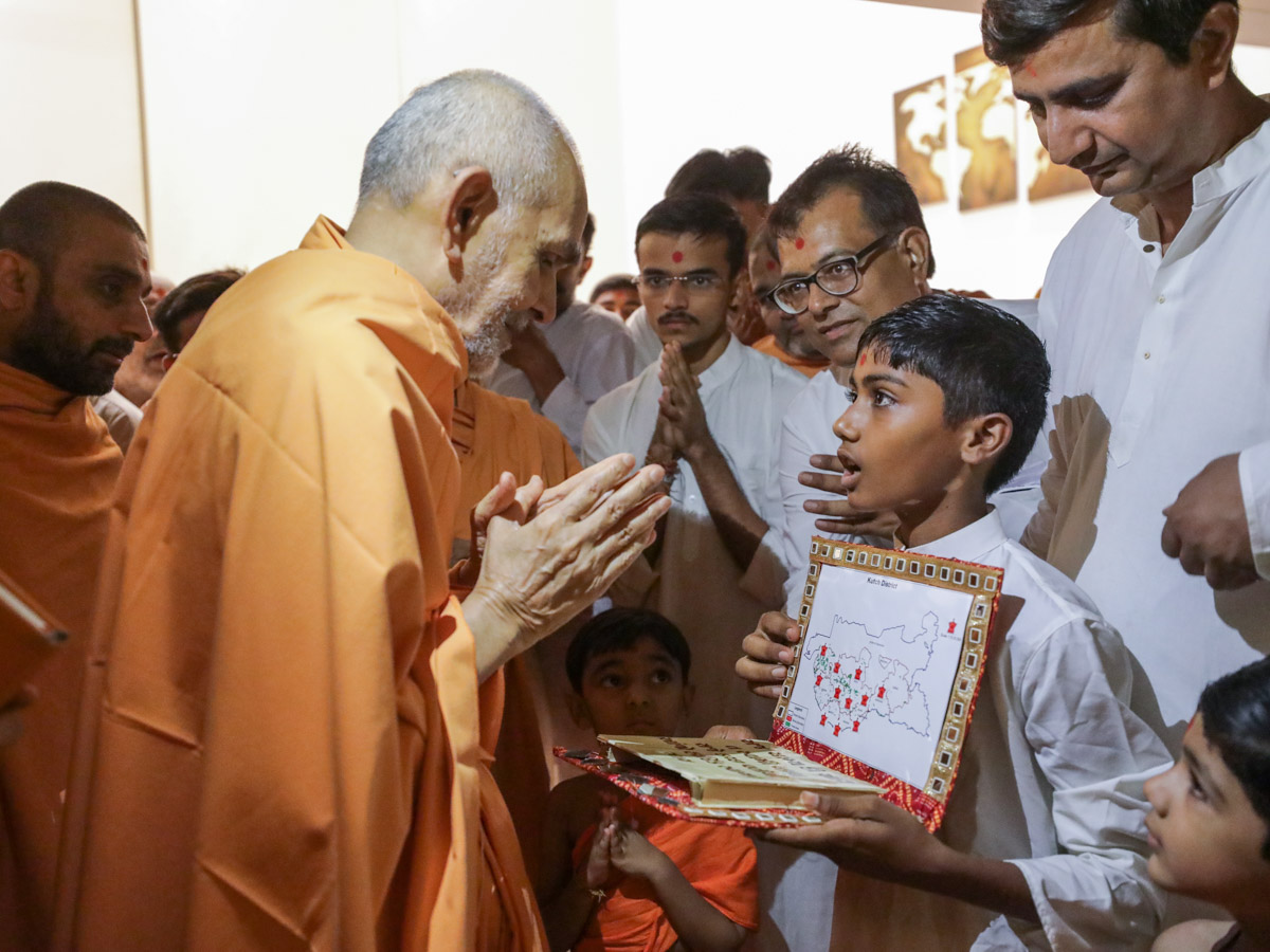 Param Pujya Mahant Swami Maharaj observes a card prepared by a child, Bhuj