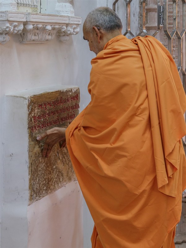 Swamishri reverentially touches a stone sanctified by Aksharbrahman Gunatitanand Swami