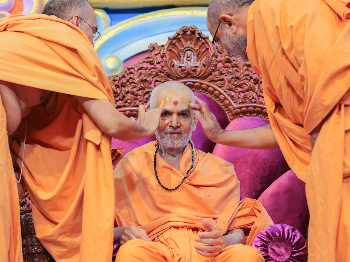 Narayanmuni Swami and Gnaneshwar Swami apply chandan to Swamishri
