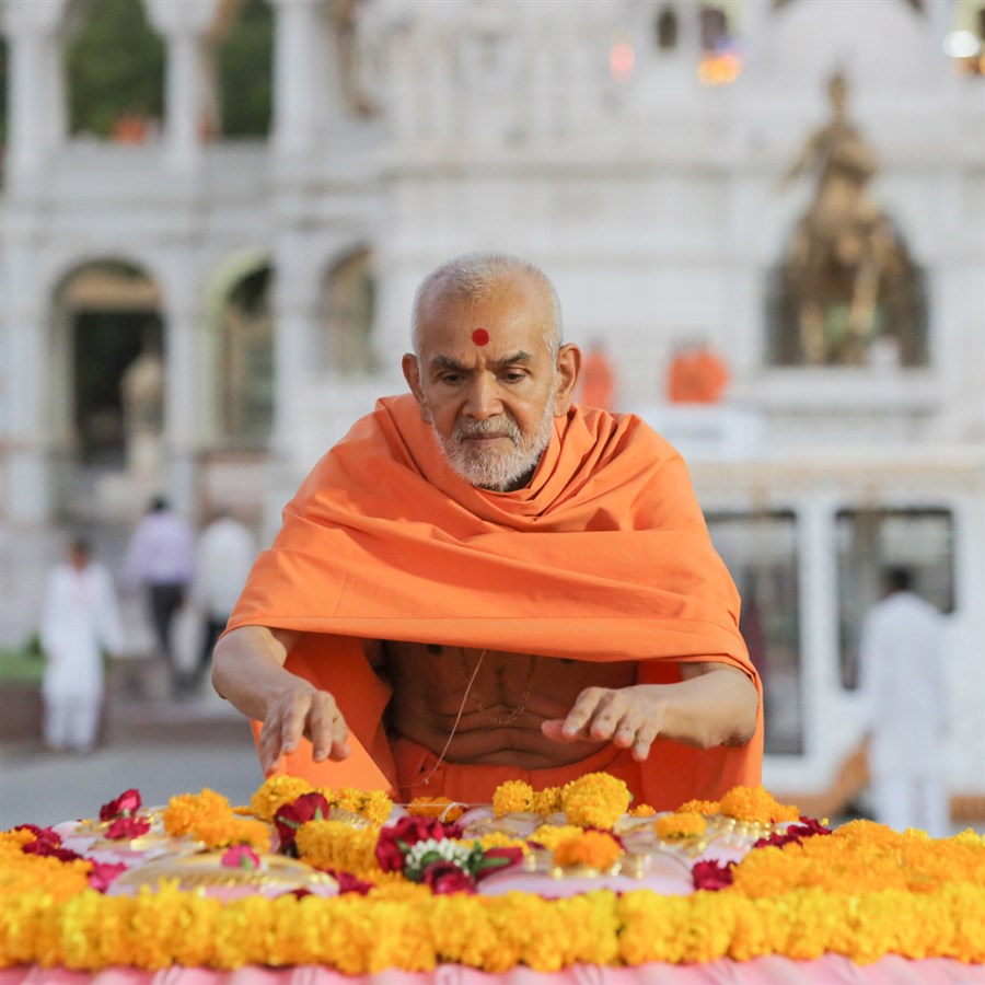 Swamishri offers a garland at Brahmaswarup Pramukh Swami Maharaj's samadhi