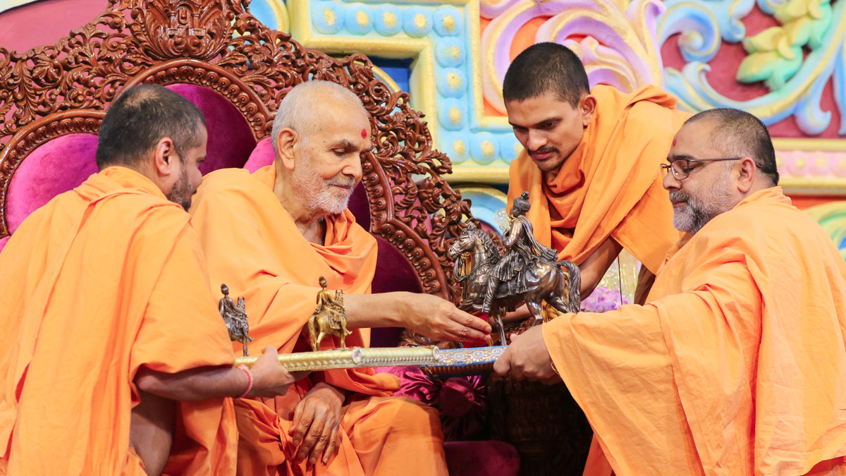 Swamishri sanctifies models of Bhagwan Swaminarayan seated on his horse, Rojo