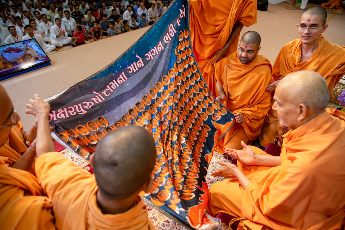 Swamishri observes a shawl