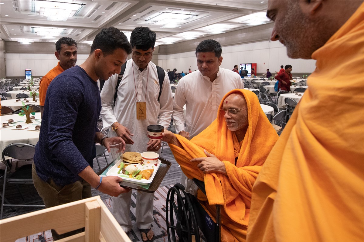 Pujya Bhaktinandandas Swami serves dinner to delegates