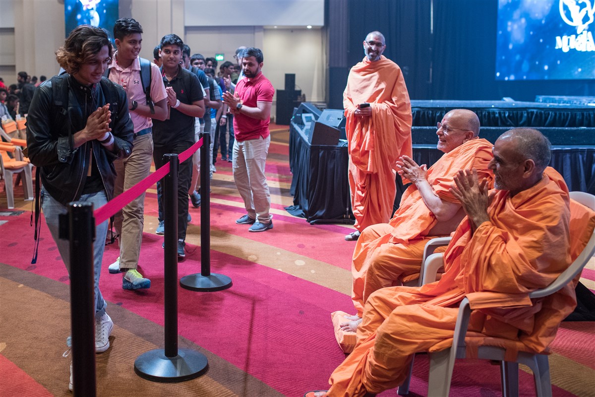 Pujya Ishwarcharandas Swami and Pujya Anandswarupdas Swami greet youth with folded hands