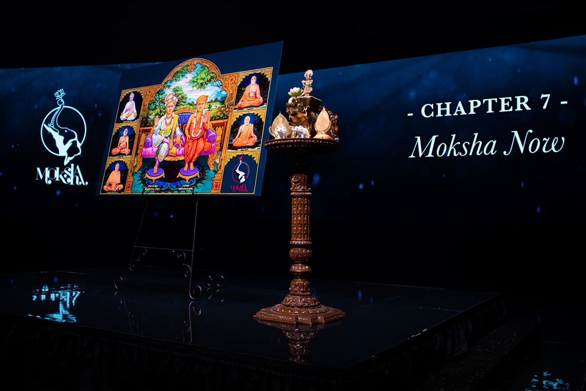 A painted murti is displayed on the stage during the evening session