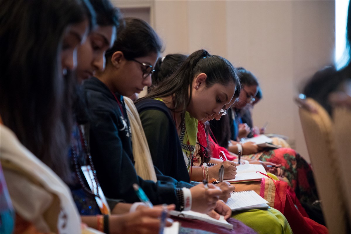 Delegates take notes in their journals