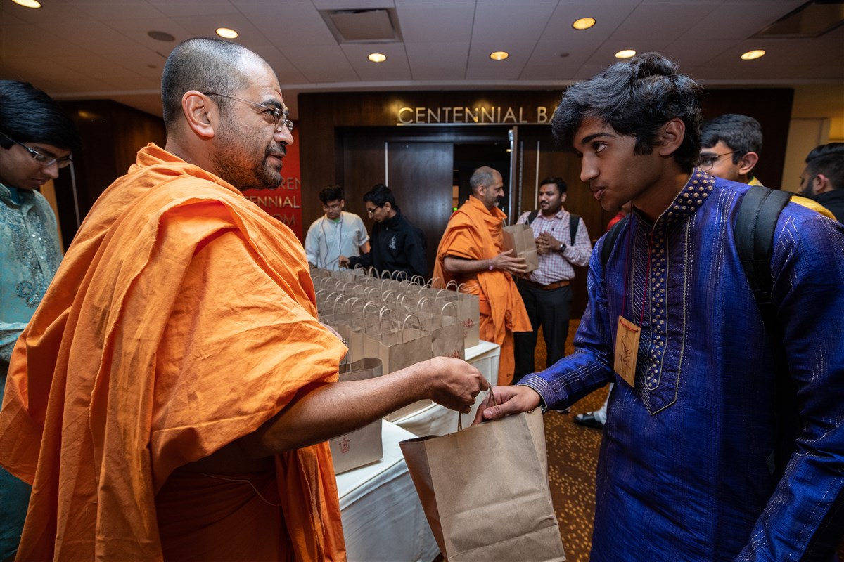 Pujya Shukmunidas Swami hands delegates convention mementos