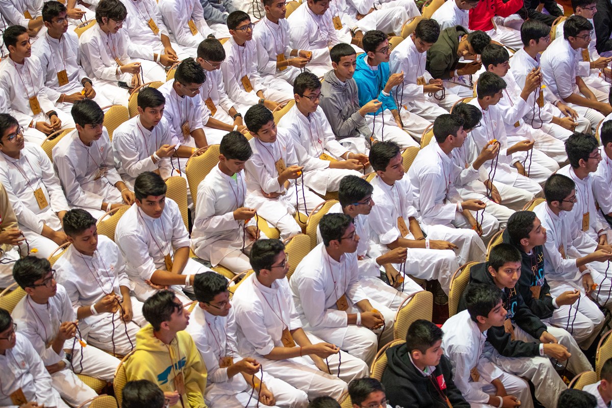 Delegates perform mala with Swamishri
