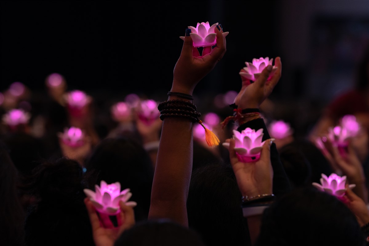 Delegates raise a lotus with Swamishri 