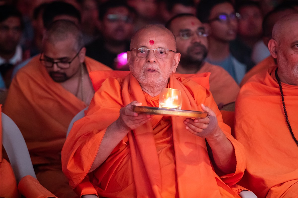 Pujya Ishwarcharandas Swami performs the evening arti