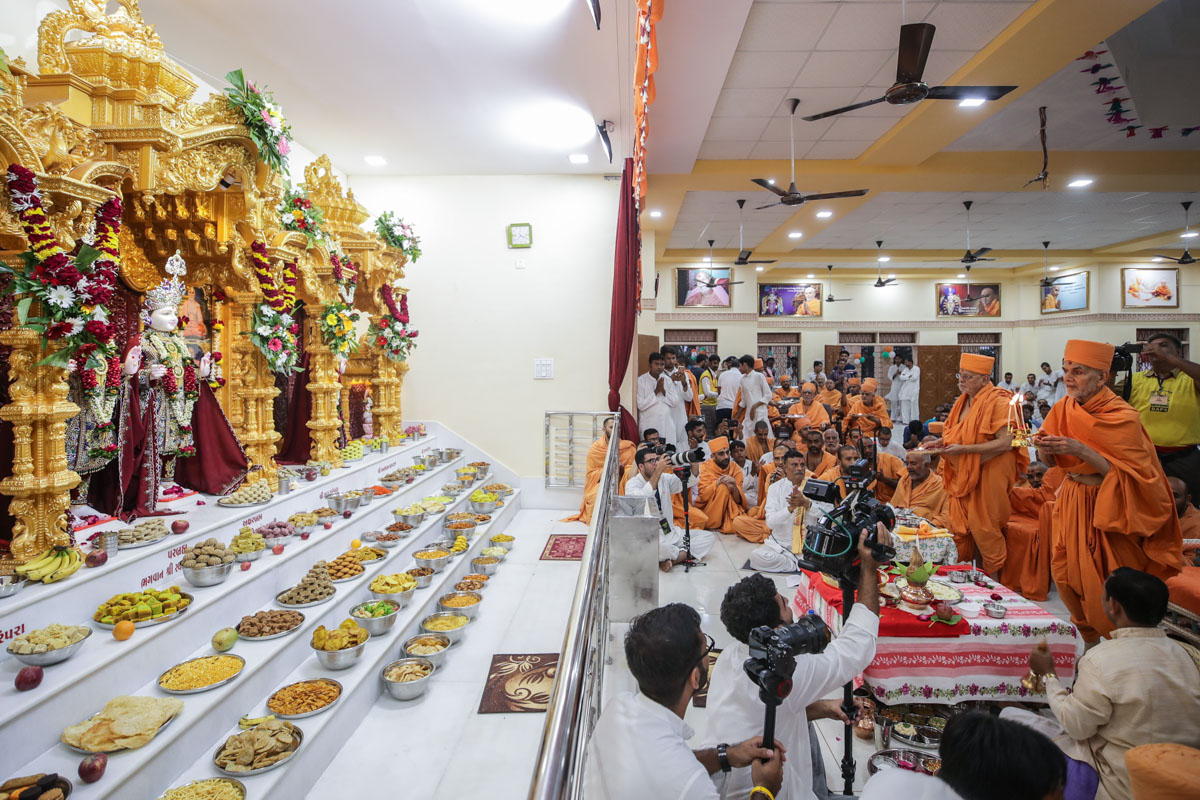 Swamishri and Pujya Ishwarcharan Swami perform the murti-pratishtha arti