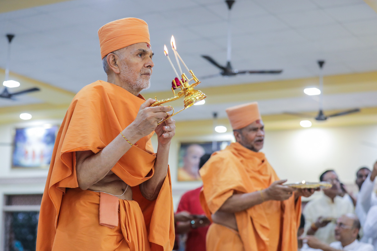 Swamishri and Narendraprasad Swami perform the murti-pratishtha arti
