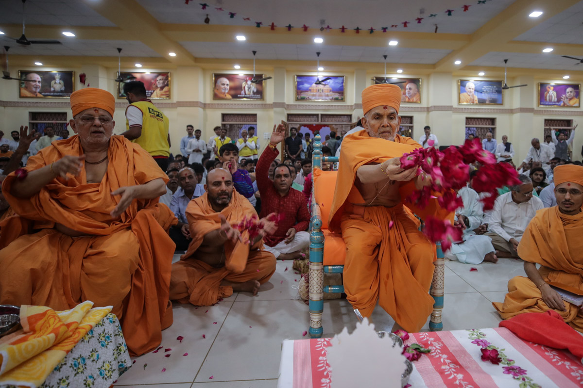Swamishri and Pujya Ishwarcharan Swami offer mantra-pushpanjali