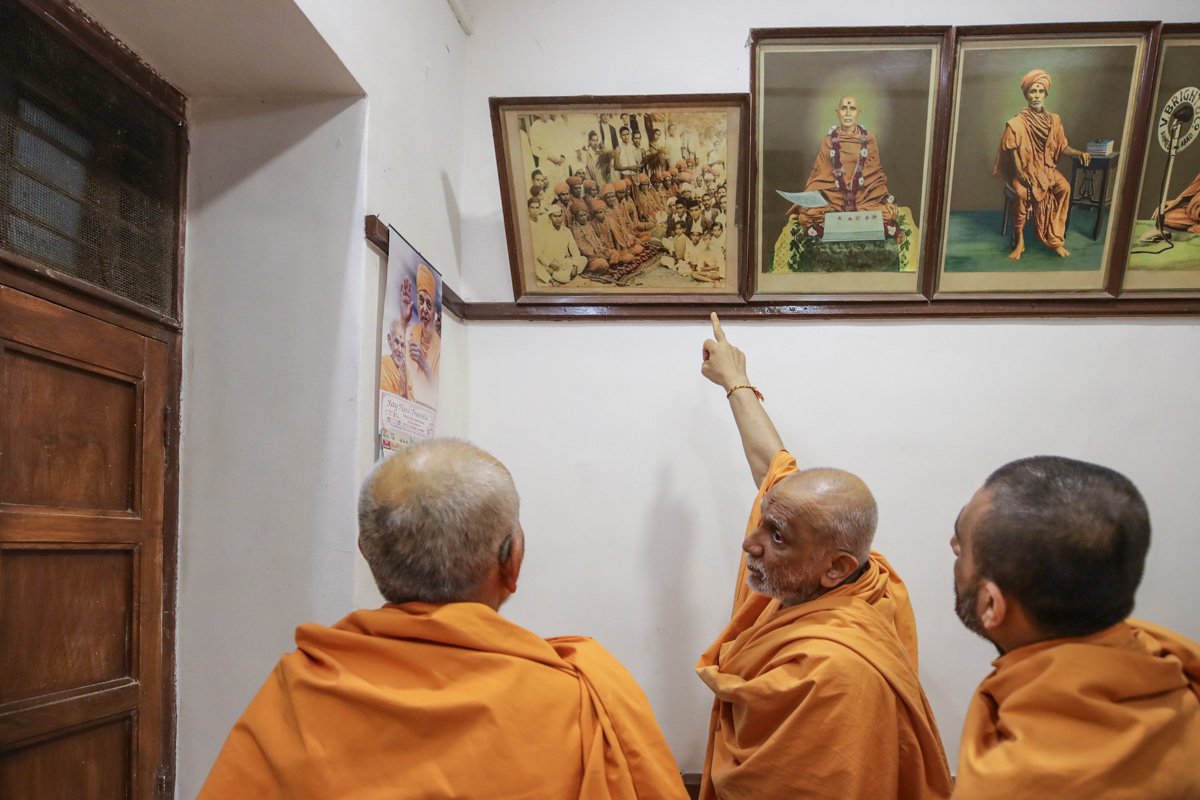 Swamishri observes an old photograph