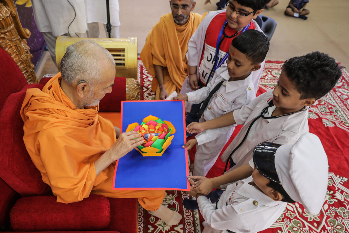 Swamishri sanctifies a creation by students of Swaminarayan Vidyamandir, Atladra