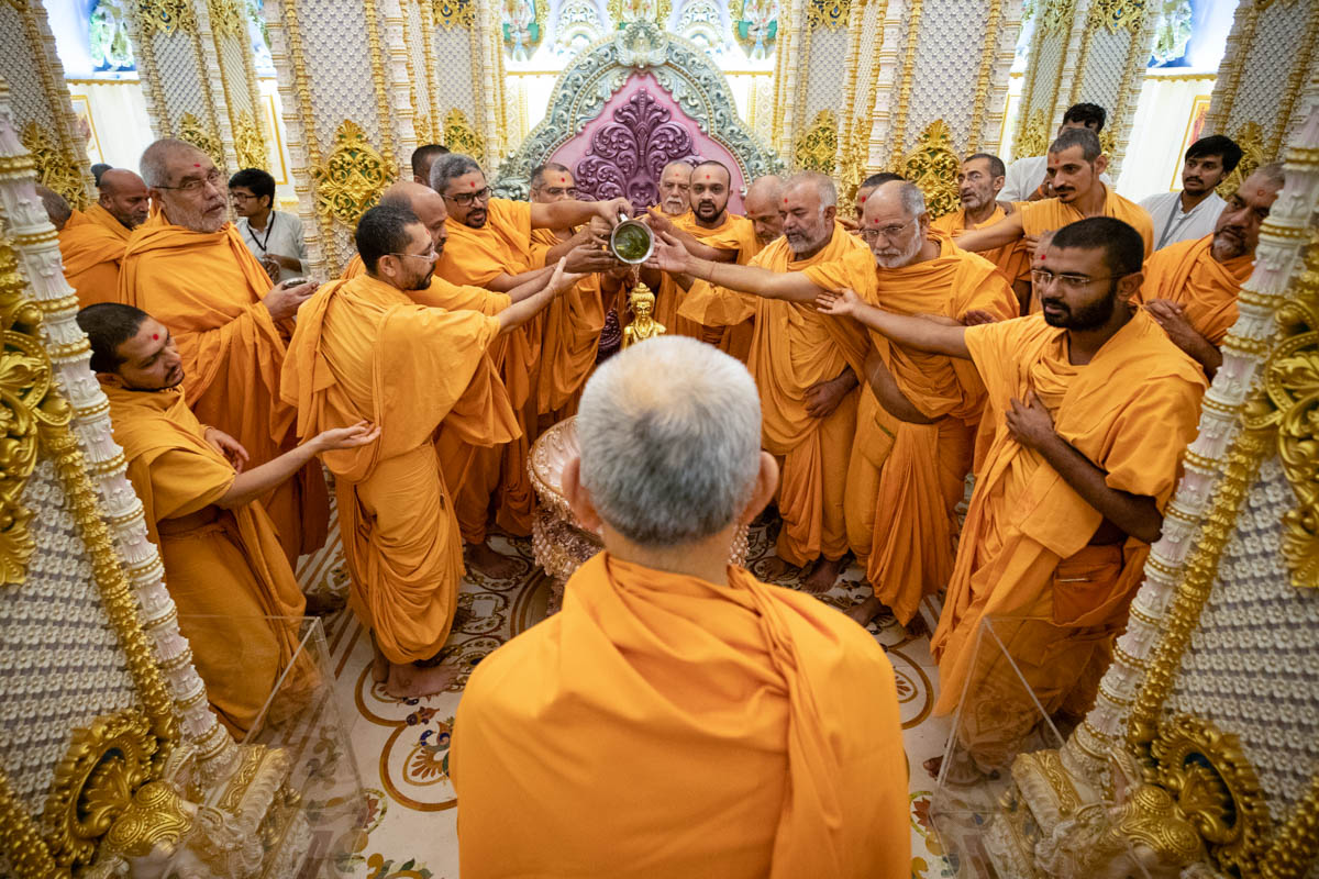 Swamishri does darshan while sadhus perform abhishek of Shri Nilkanth Varni