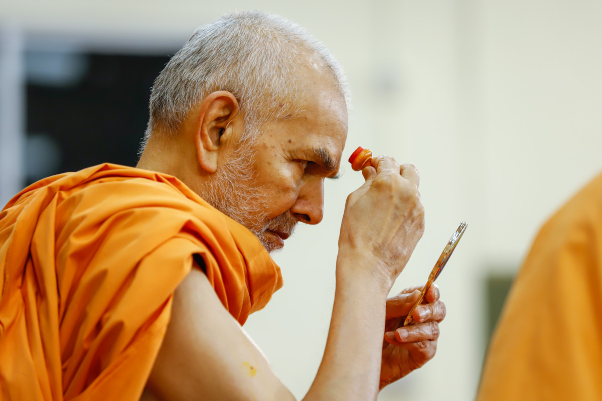 Swamishri applies chandlo in his morning puja