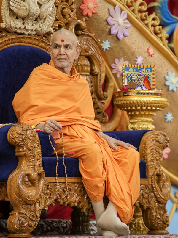 Swamishri doing mala during the evening assembly