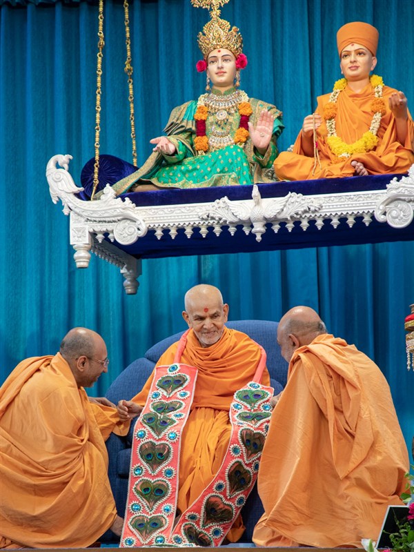 Sadhus honor Swamishri with a garland of peacock feathers