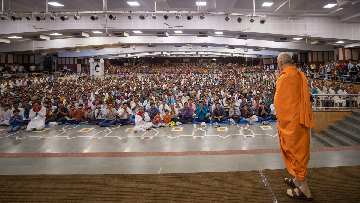 Swamishri greets devotees with 'Jai Swaminarayan' in the Pramukh Swami Auditorium