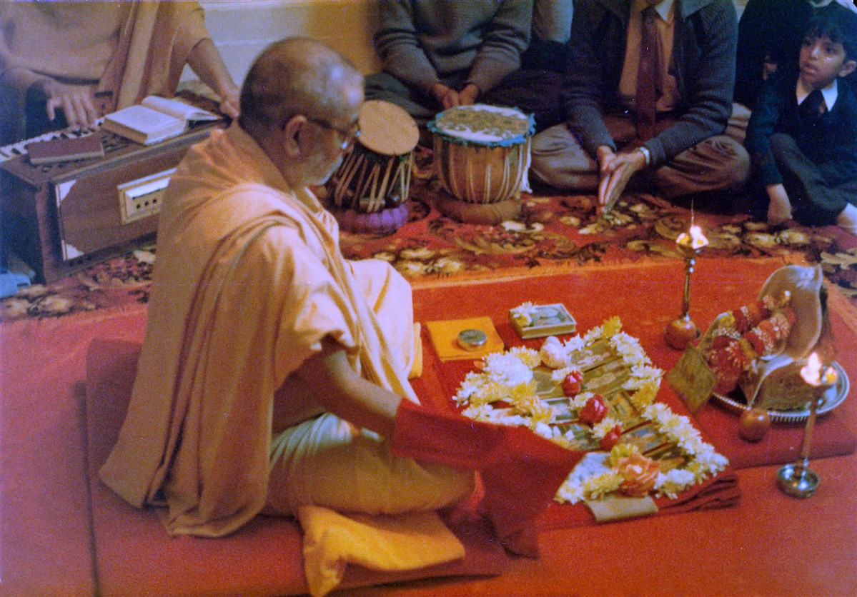 Pramukh Swami Maharaj performs his morning puja at the home of a devotee, Wanstead, 1980