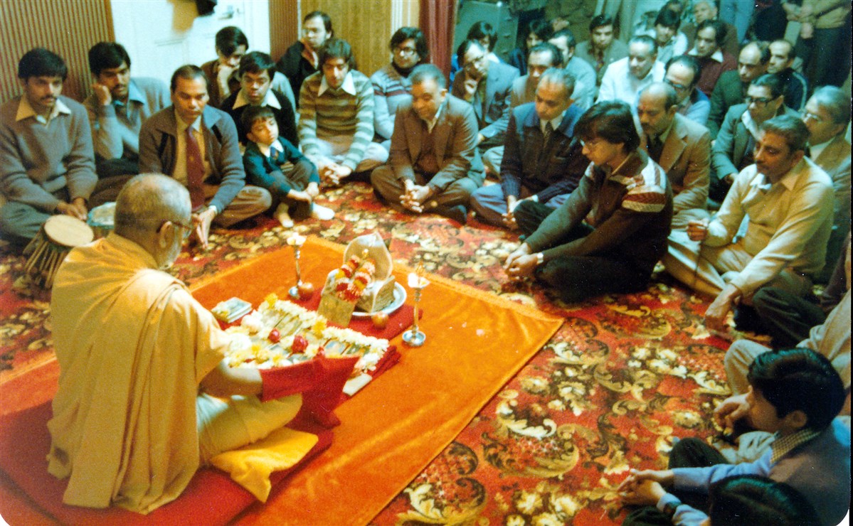 Pramukh Swami Maharaj performs his morning puja at the home of a devotee, Wanstead, 1980