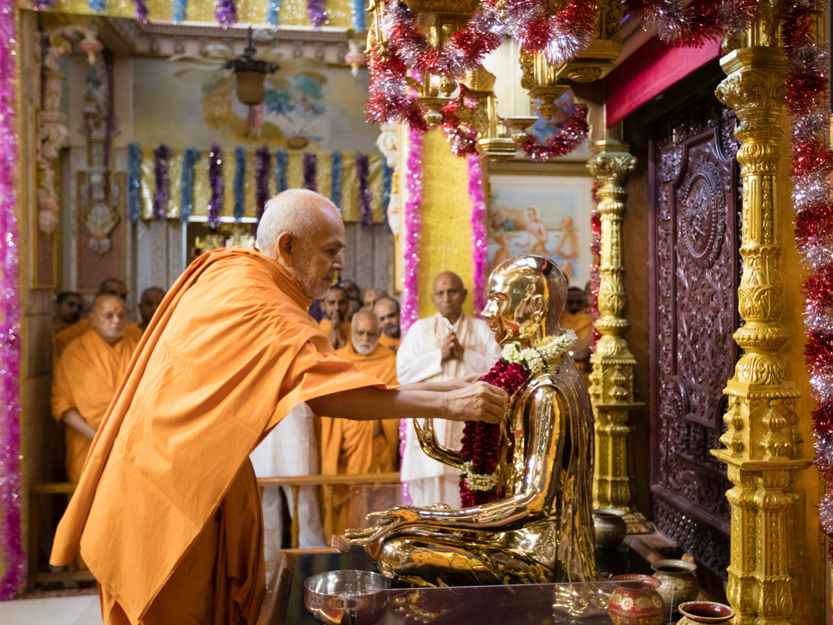 Swamishri honors Bhagwan Swaminarayan with a garland
