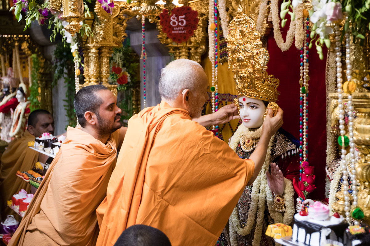 Swamishri adorns Bhagwan Swaminarayan with a new mugat and kundals