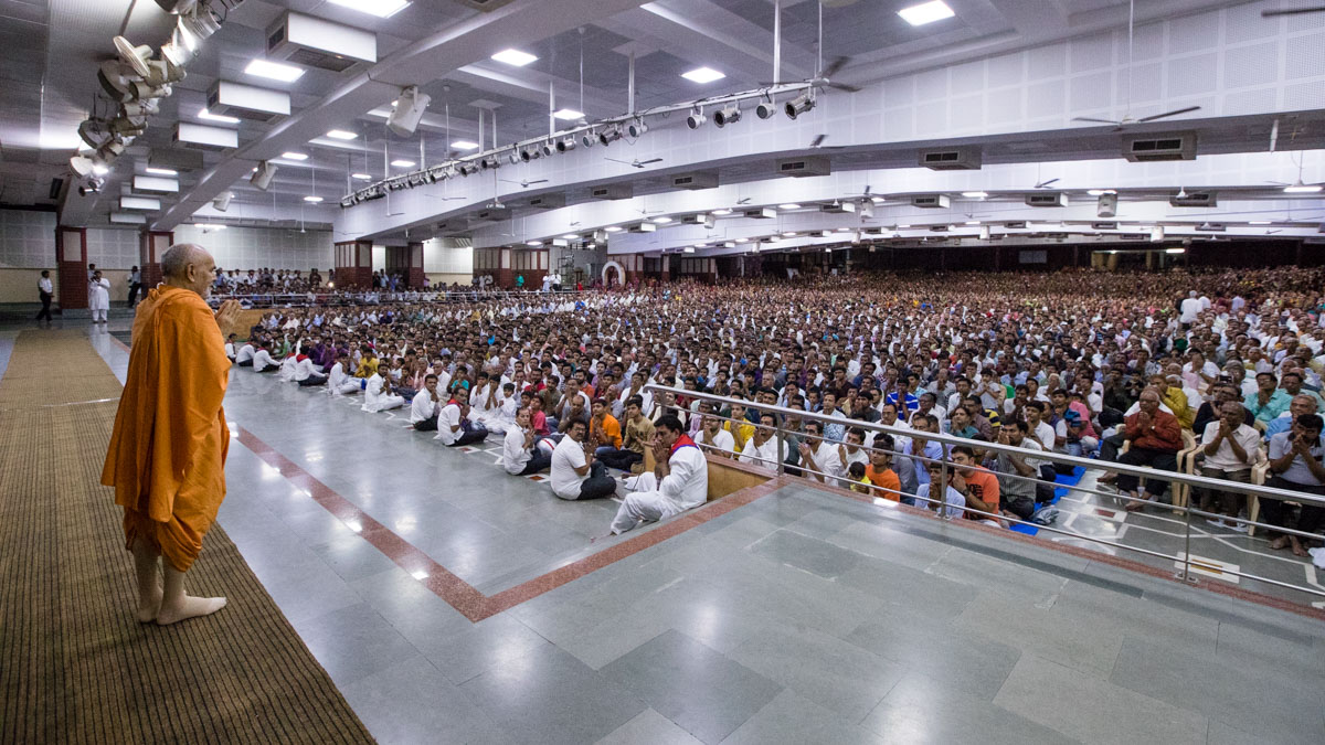 Swamishri greets devotees with 'Jai Swaminarayan' in the Pramukh Swami Auditorium