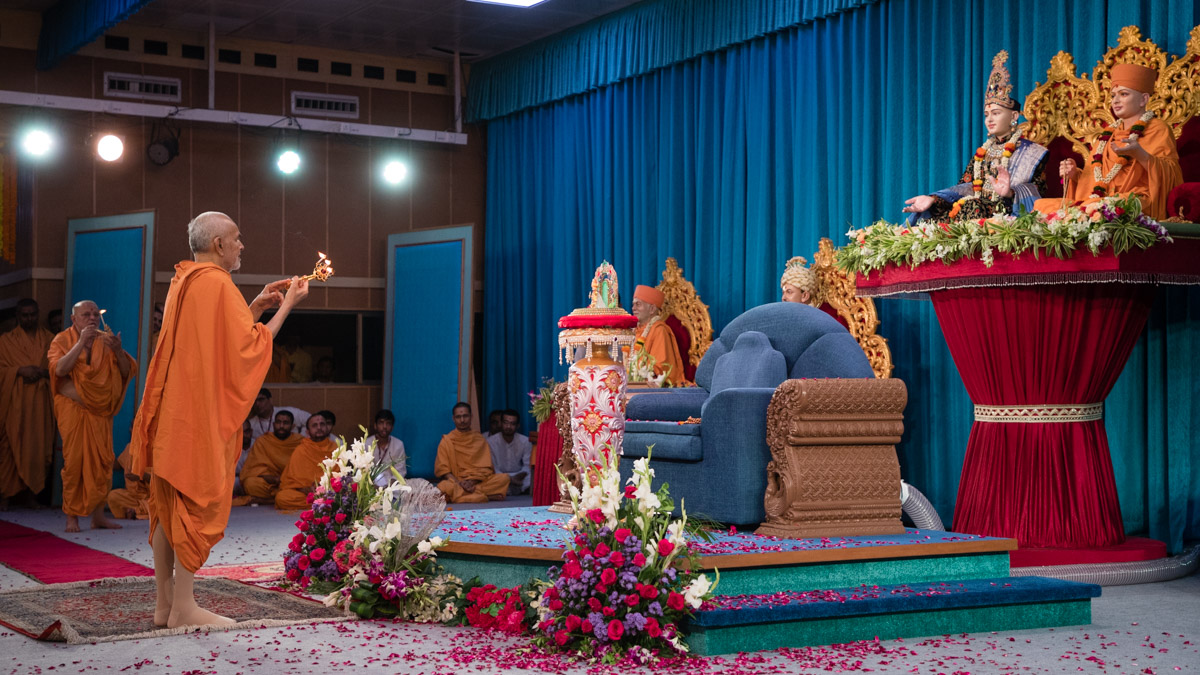 Swamishri and Pujya Ishwarcharan Swami perform the evening arti