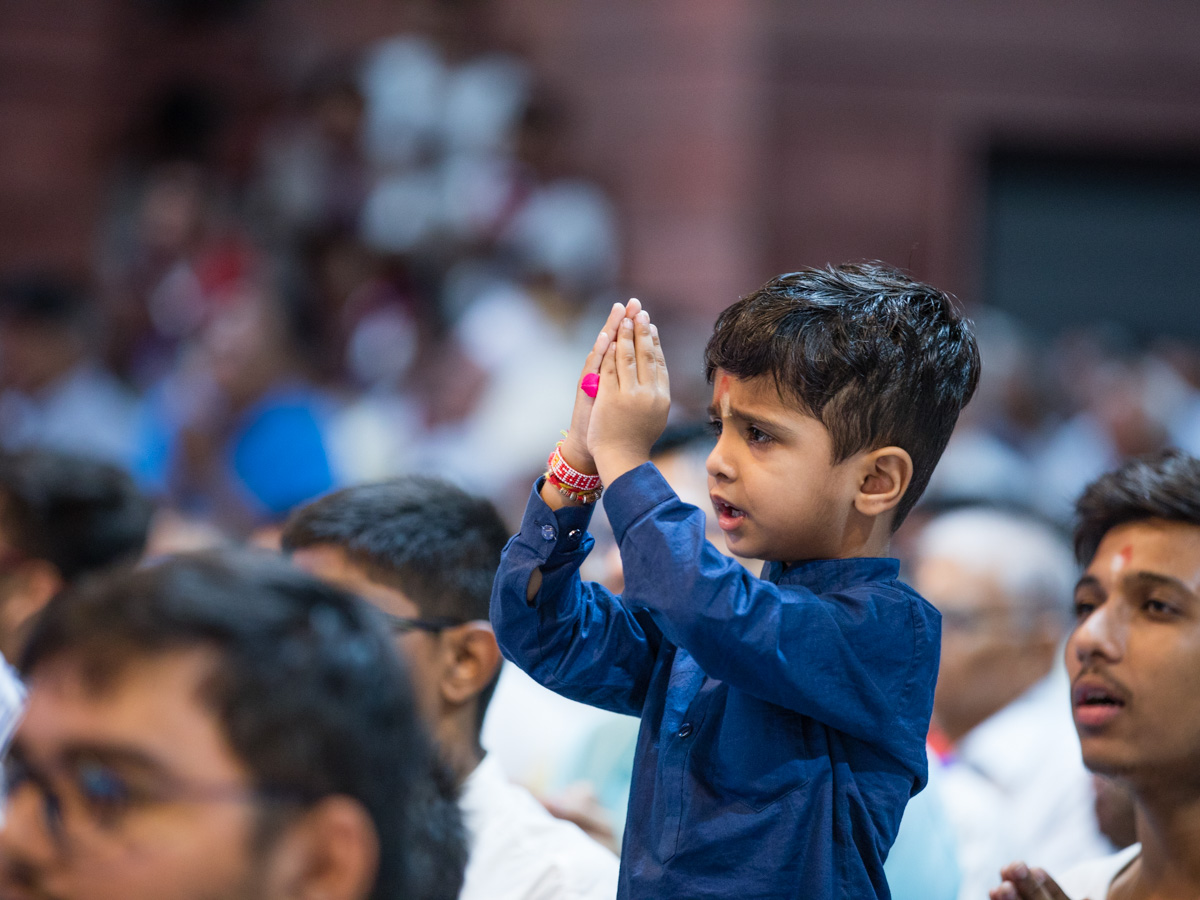 A child offers mantra-pushpanjali