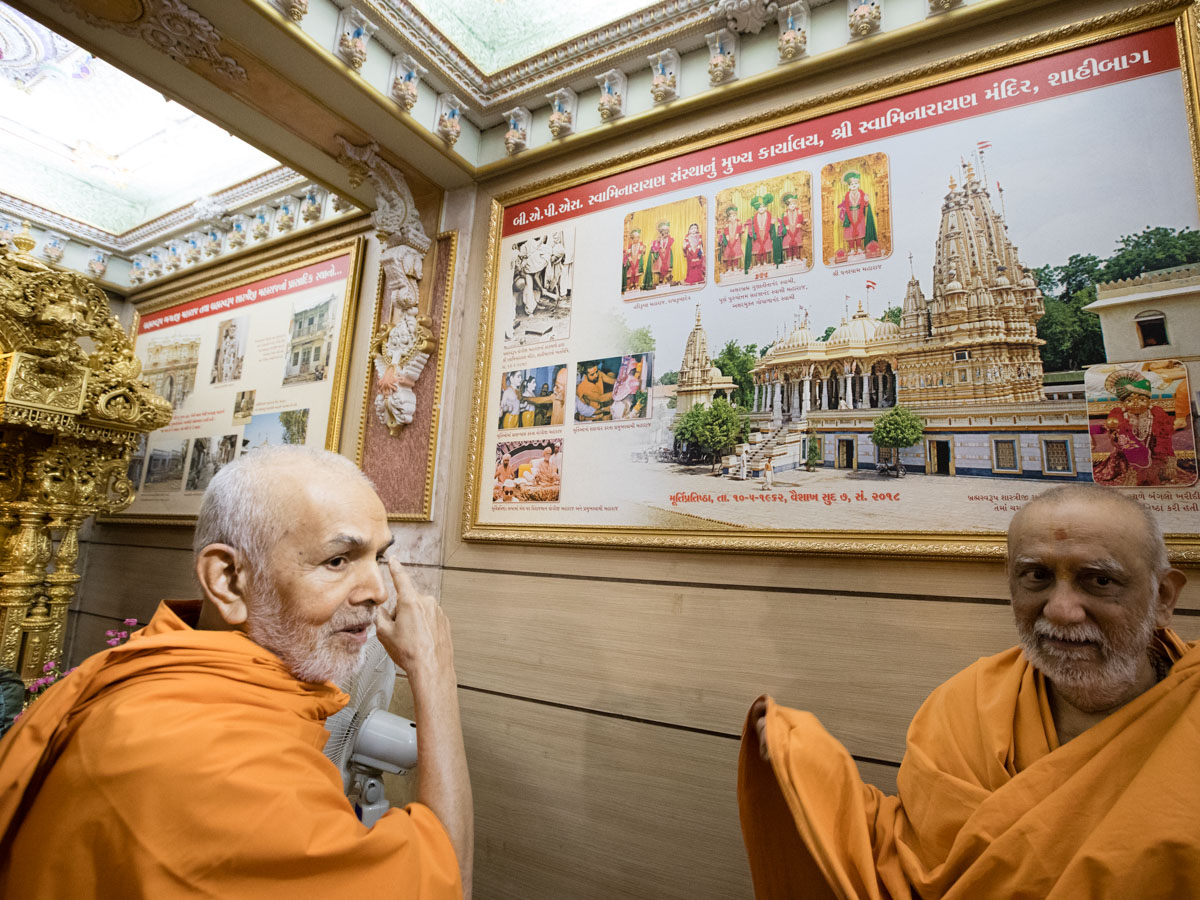 Param Pujya Mahant Swami Maharaj observes a photo in the abhishek mandapam