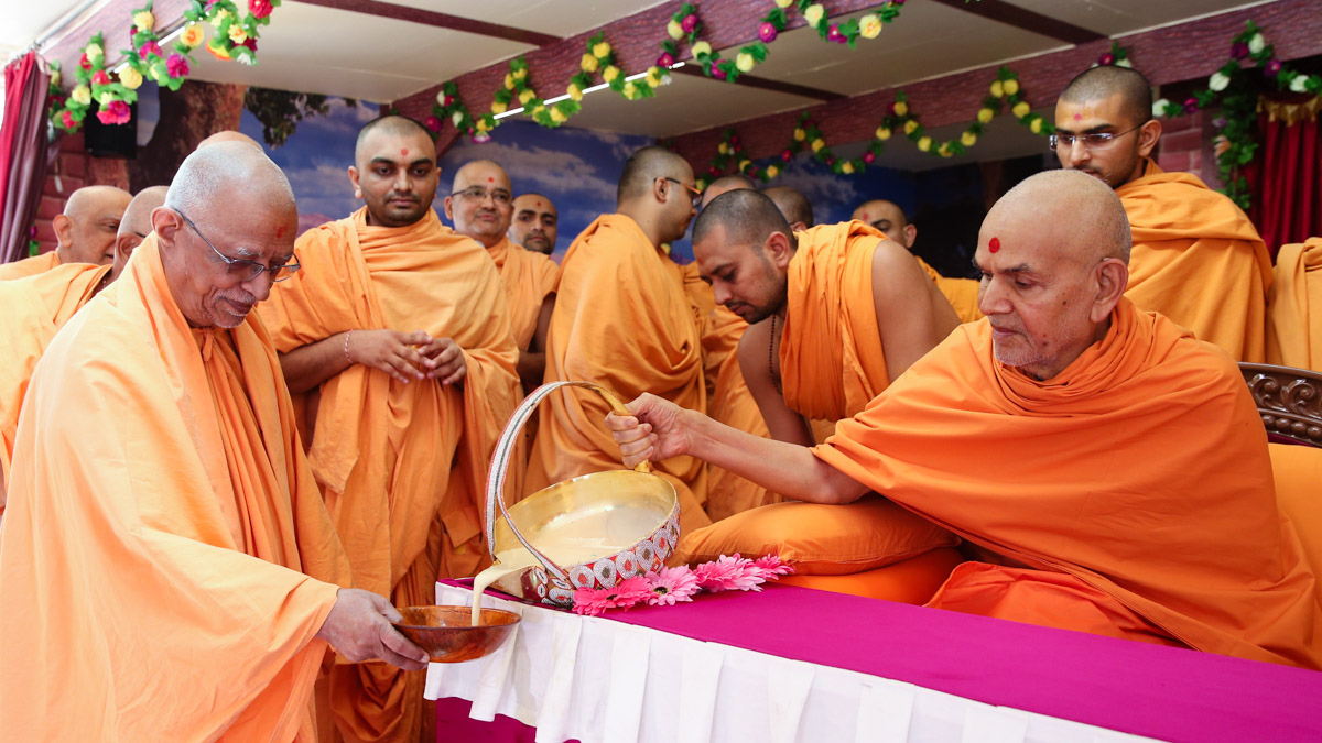 Swamishri serves dudhpak to Pujya Swayamprakash Swami (Doctor Swami)