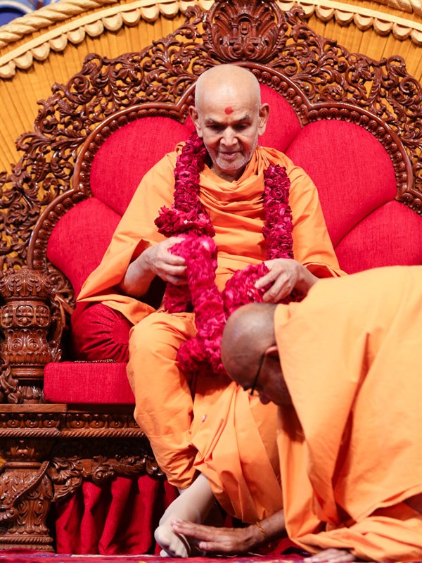 Gnaneshwar Swami honors Swamishri with a garland