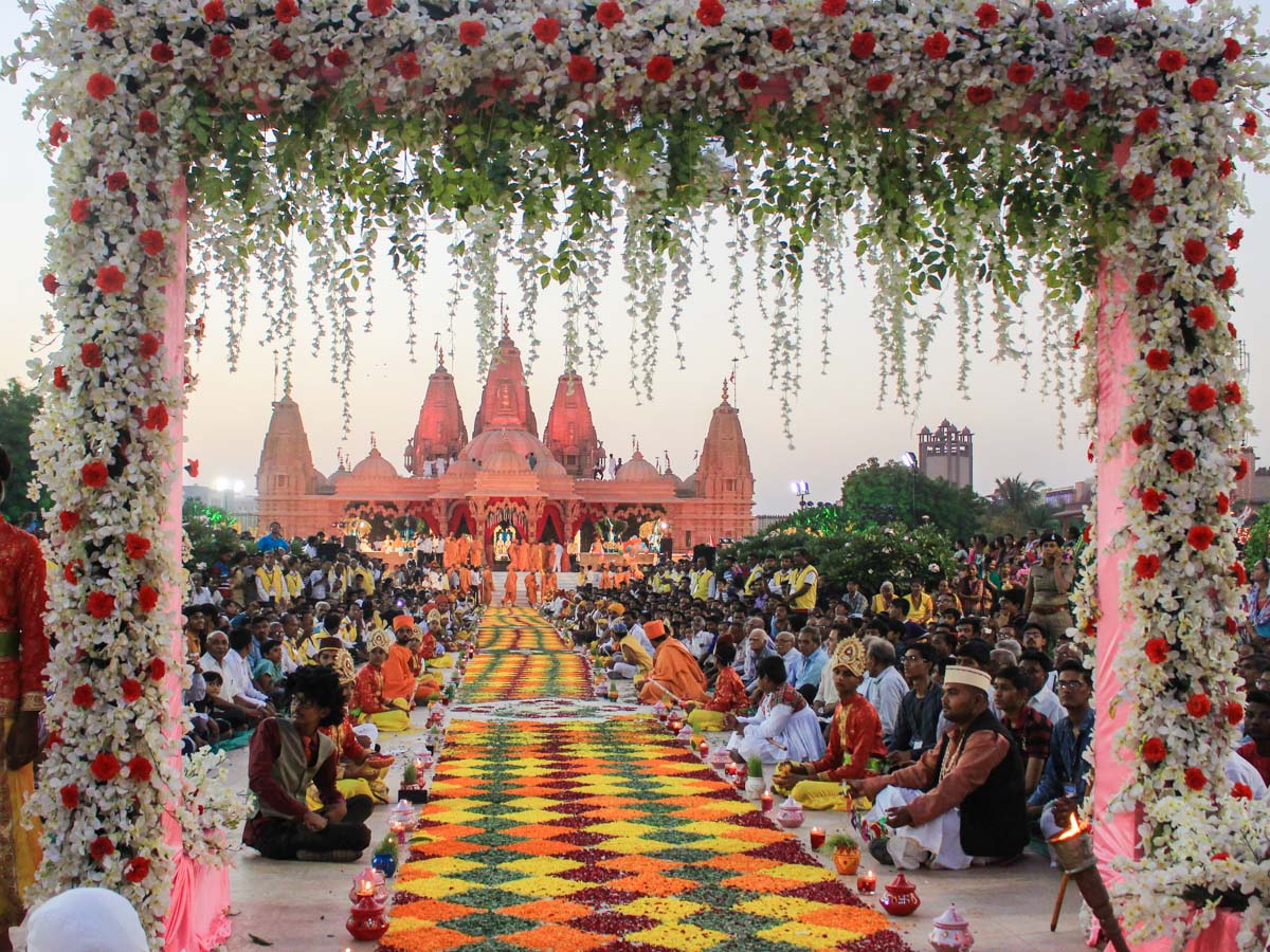 Devotees wait in the mandir grounds to welcome Swamishri