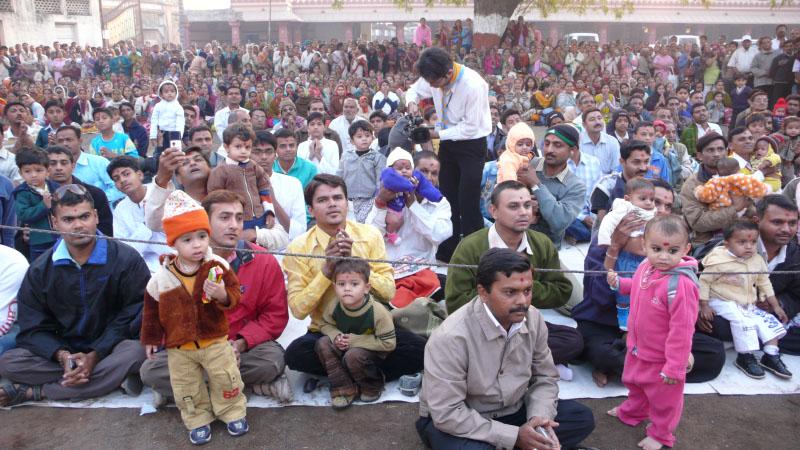 Swamishri initiates babies into satsang by chanting the vartman mantra