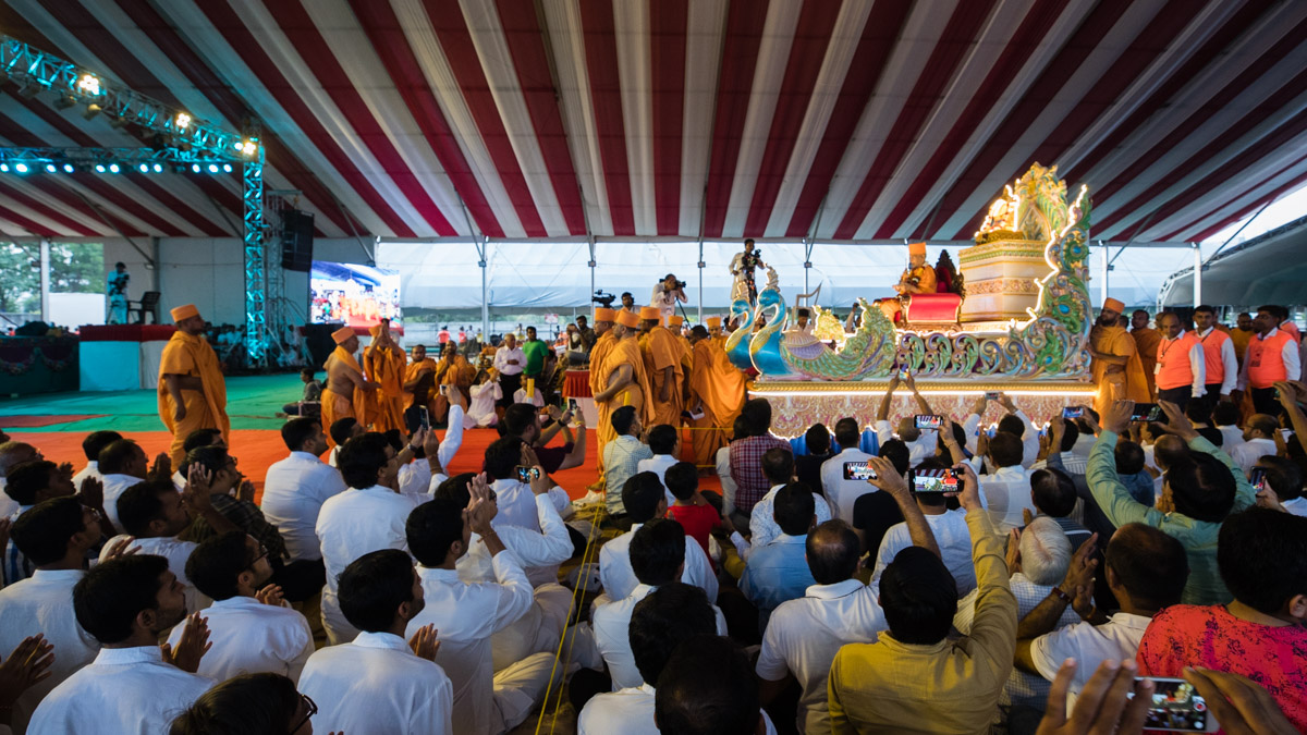 Devotees welcome Swamishri on a chariot