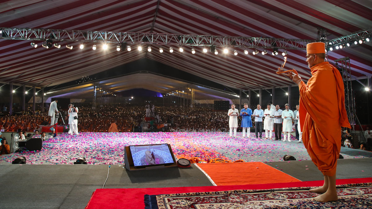Swamishri, guests and devotees perform the arti