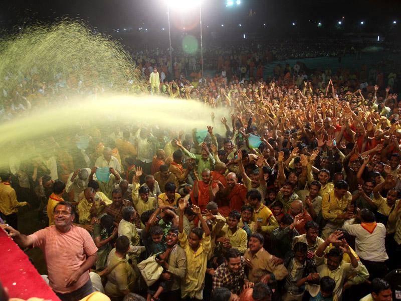  Swamishri showers sanctified colored water on devotees 