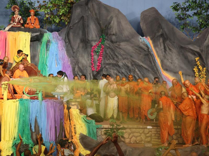 Swamishri showers sanctified colored water on devotees 